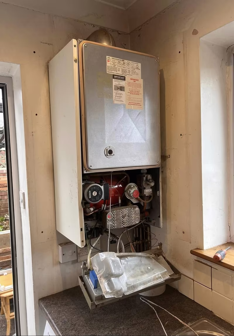 Old boiler with its casing open and the pump and internals exposed for diagnosis