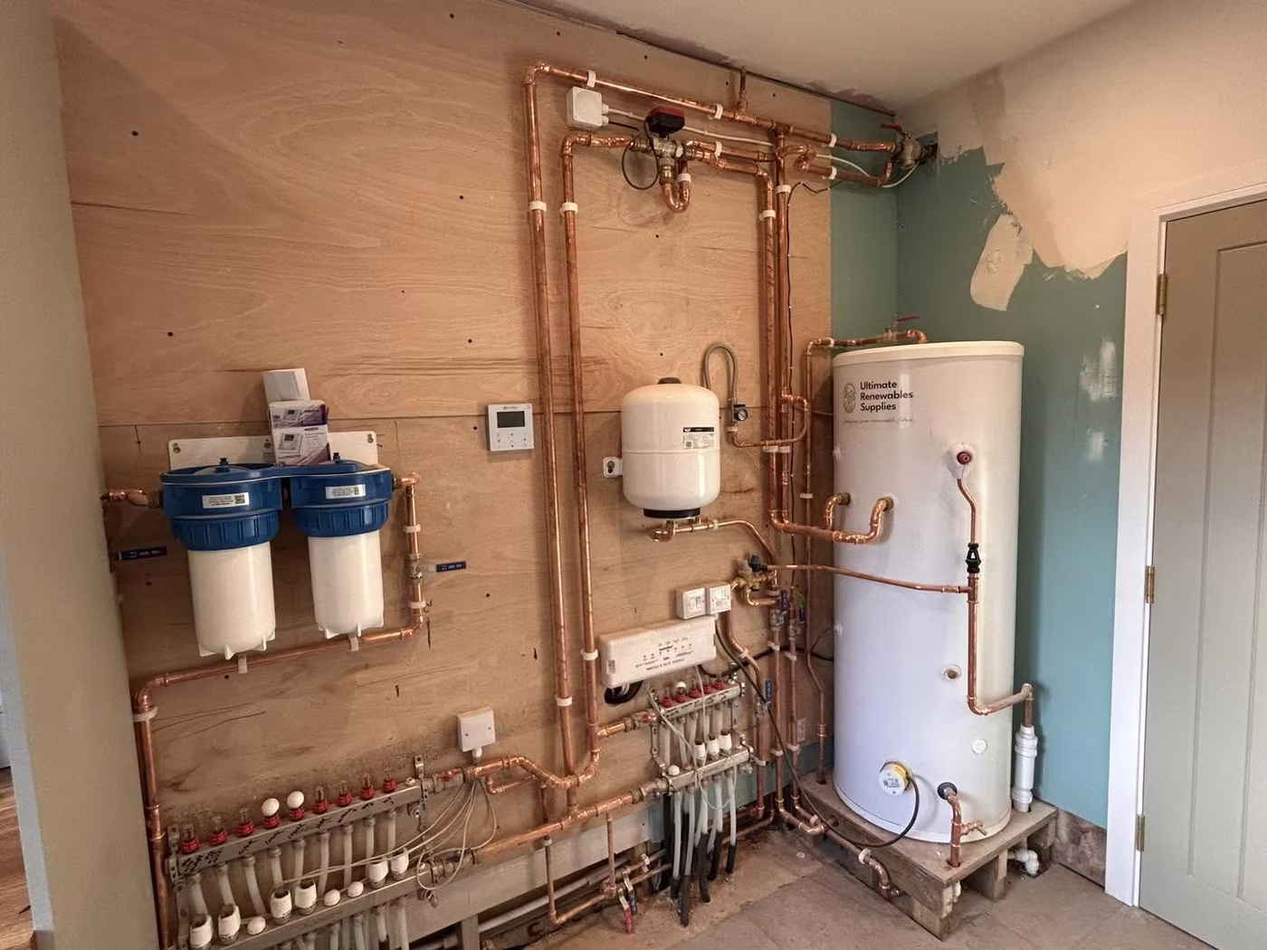 Plant room board with water filters, cylinder, manifolds and copper pipework mounted on plywood